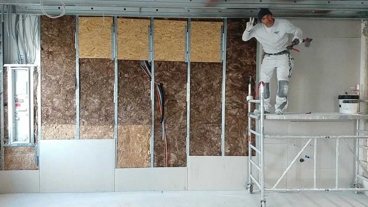 Trockenbauinstallation in Westhausen: Bauarbeiter montiert Trockenbauwände mit Dämmmaterial und Kabelverlegung für Innenausbau. Professionelle Trockenbauarbeiten in Neuler und Umgebung.